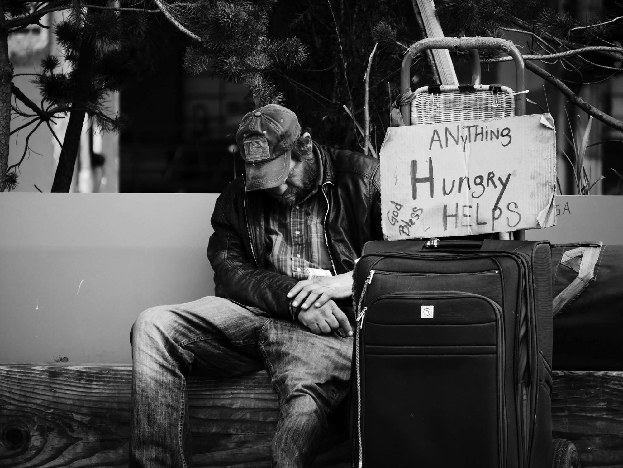 Homeless man holds Hungry sign