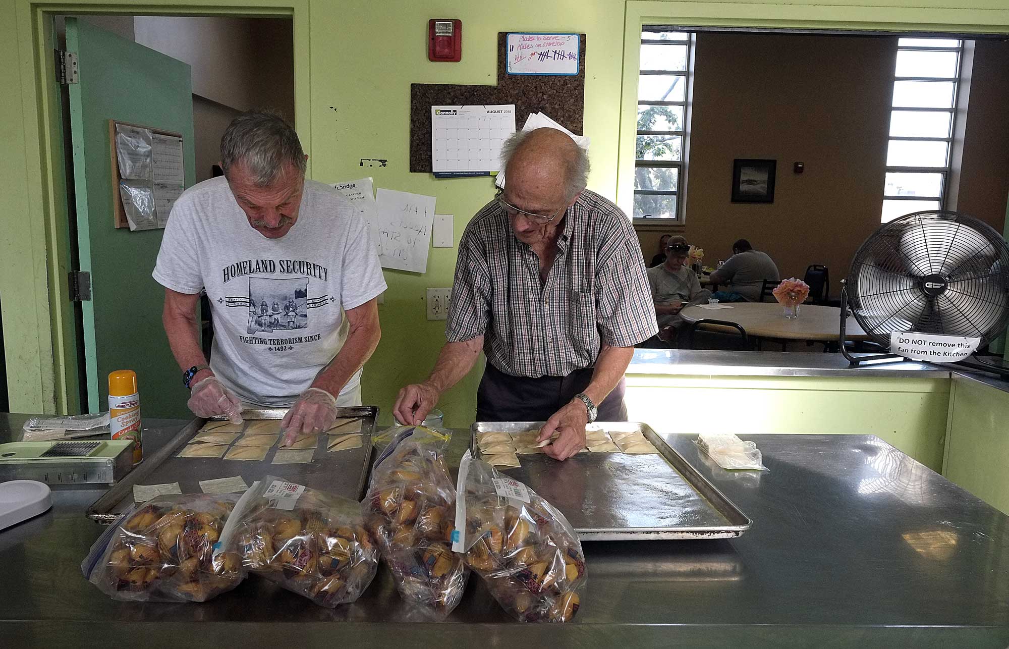 two men helping with community meals