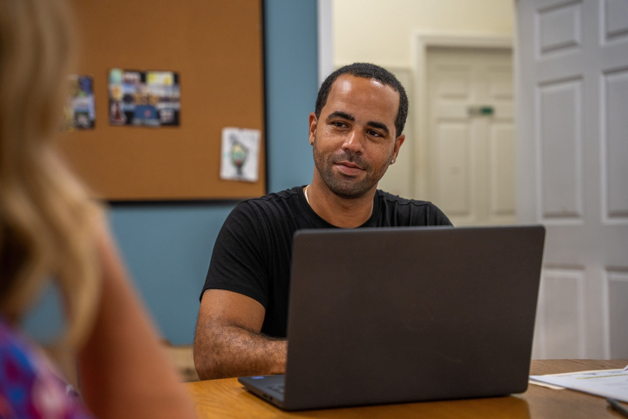 A Lifebridge staff member consulting with a client at his desk.