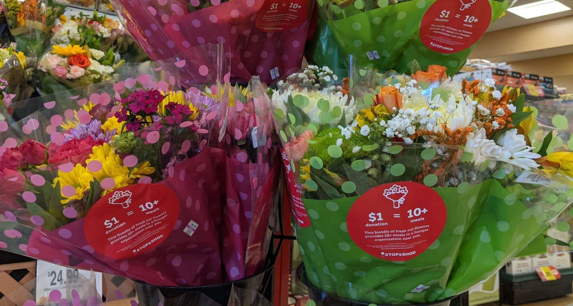 Close up of flower boutgets with stickers describing that part of the money from purchasing the flowers goes to feeding families in need.