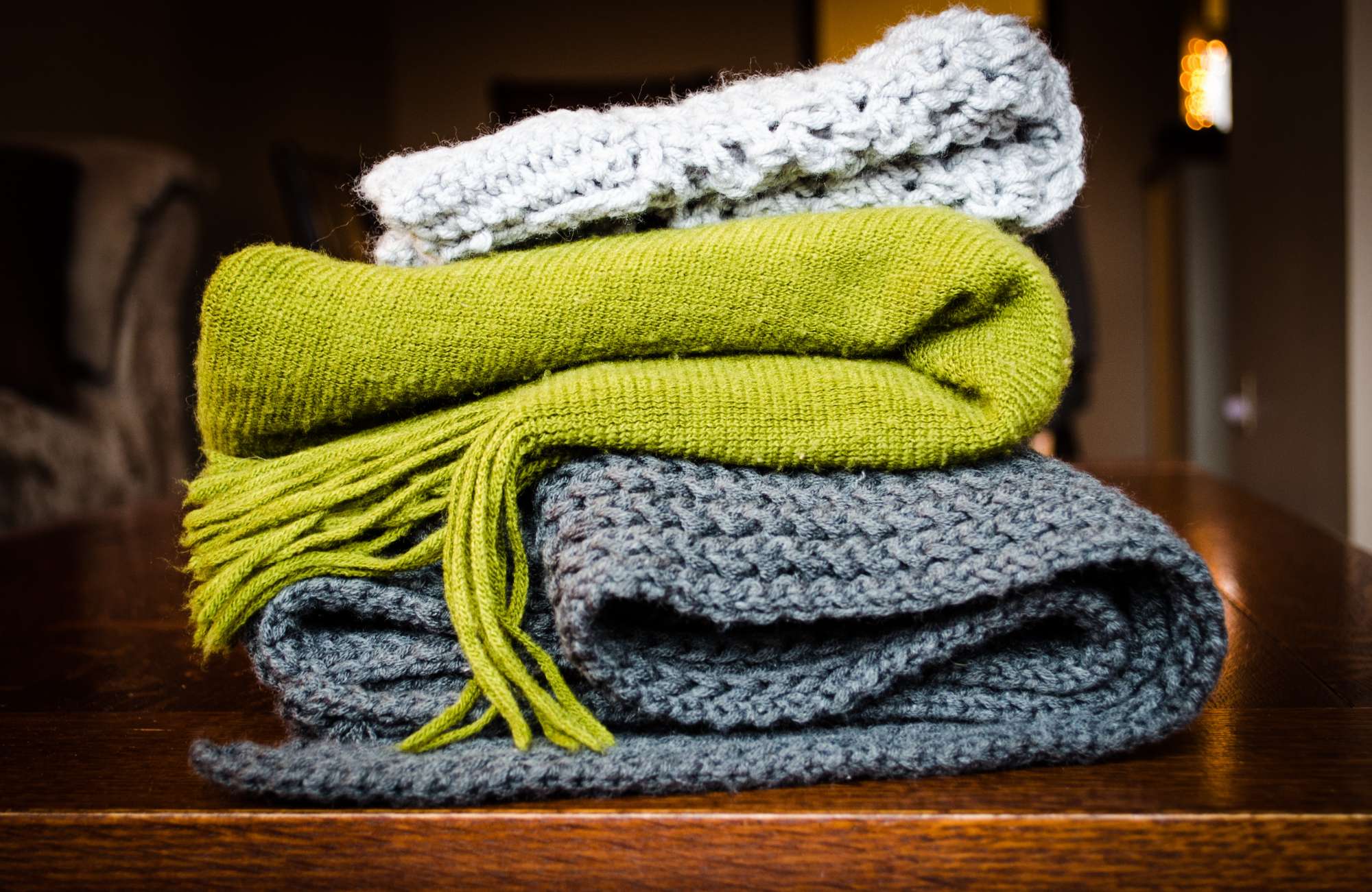 Three knit blankets stacked on top of one another.