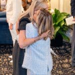 Two guests embrace at "Together for Women"