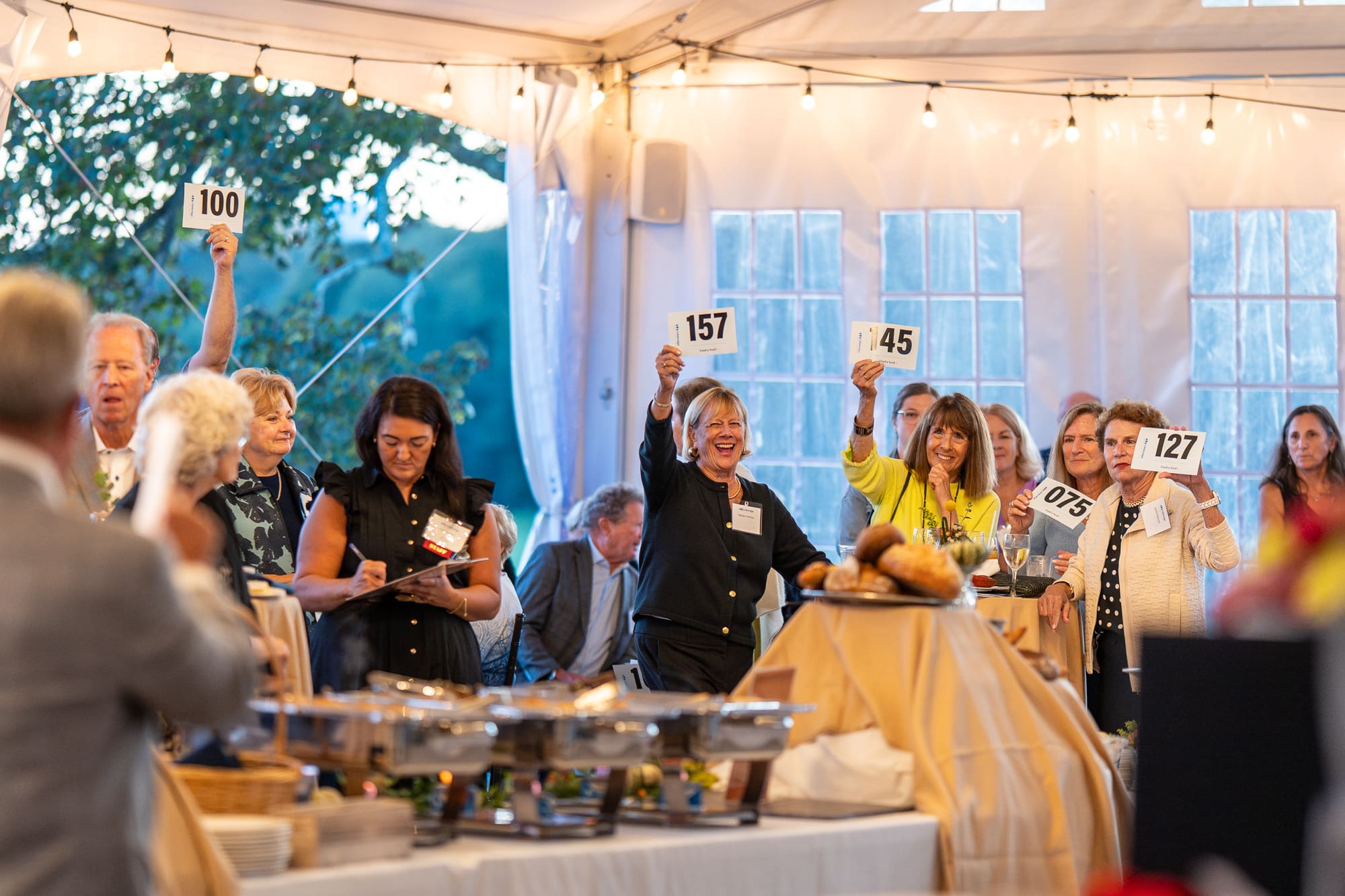 Guests raise their paddle at the Fund-a-Need for Breaking Bread, Building Hope