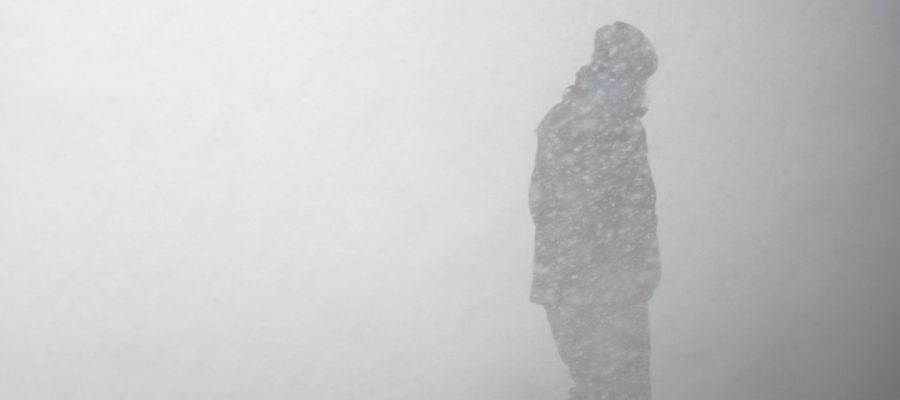 a man walks through a snow storm