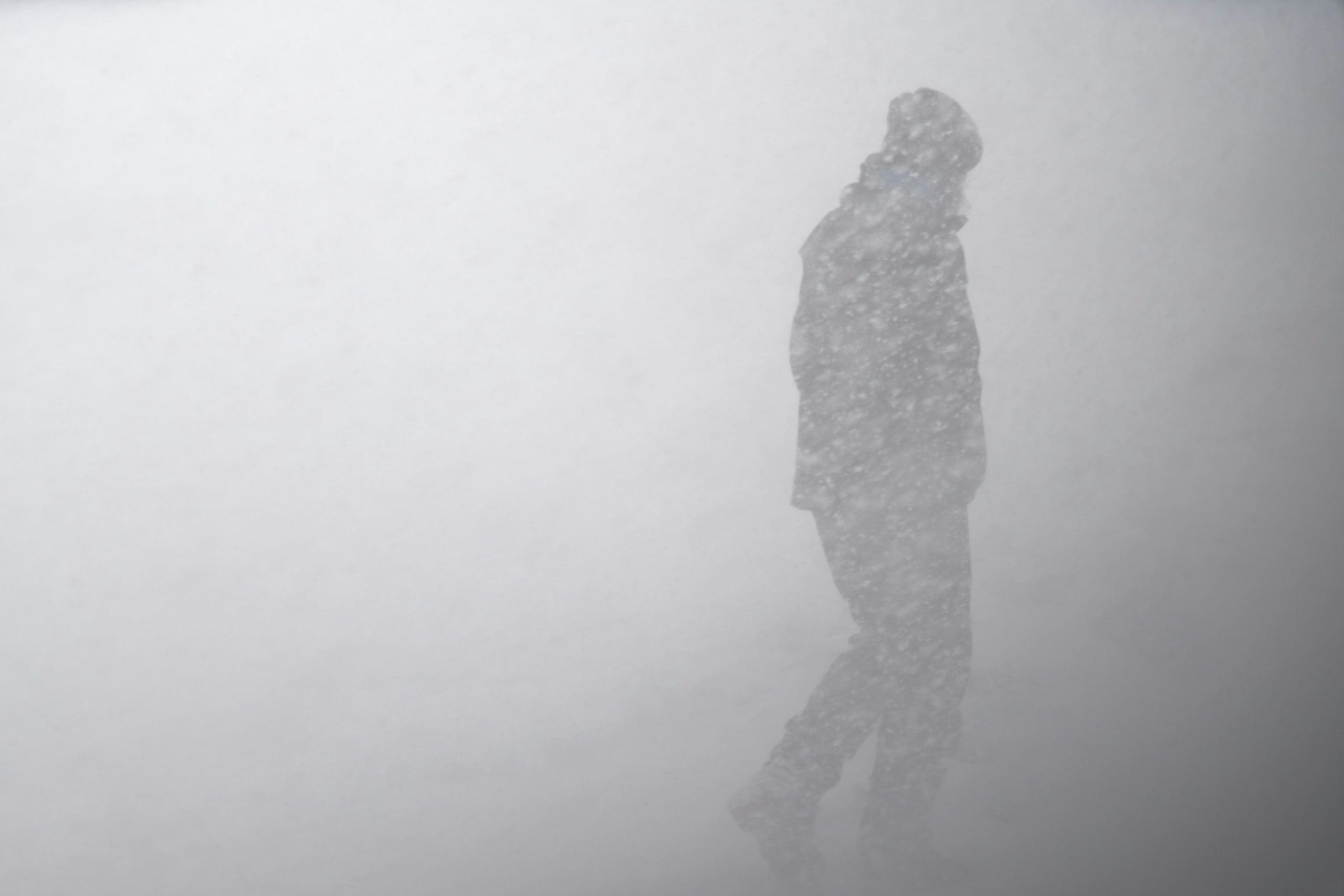 a man walks through a snow storm