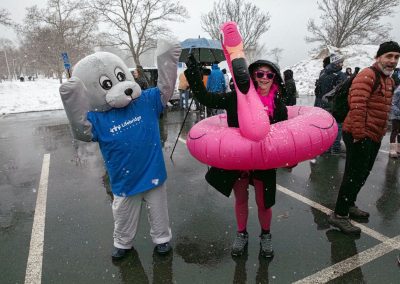 A seal mascot dancing with a woman wearing a flamingo innertube