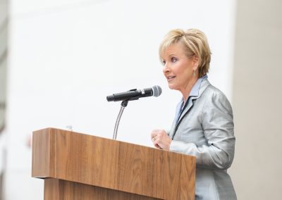 A woman is speaking at a podium into a microphone.