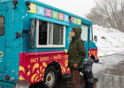 A man and a child ordering from the Ruta Jalisco food truck.