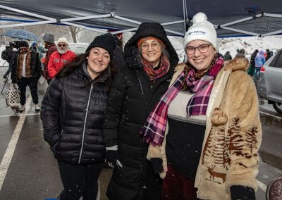 Three lifebridge employees in their coats and winter wear, smiling at the camera.