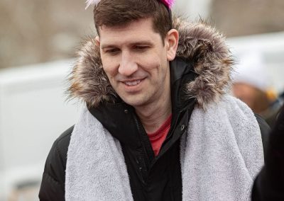 Man with a little pink flamingo toy sitting on his head.