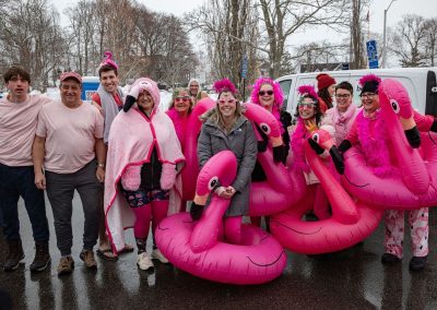 Group of plungers in pink shirt, pink flamingo floaties and colorful sunglasses.