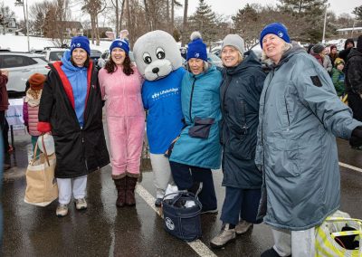 Group of women plungers smiling and posing with the Shoebert mascot.