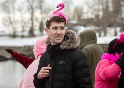 Man with a pink flamingo headband and black jacket.
