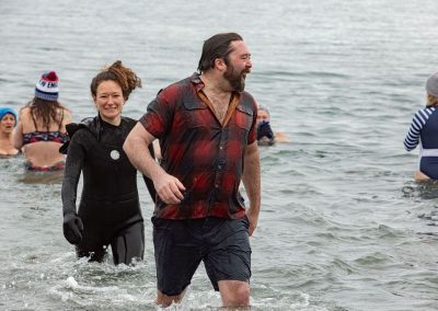 Man and Woman smiling walking out of the water.