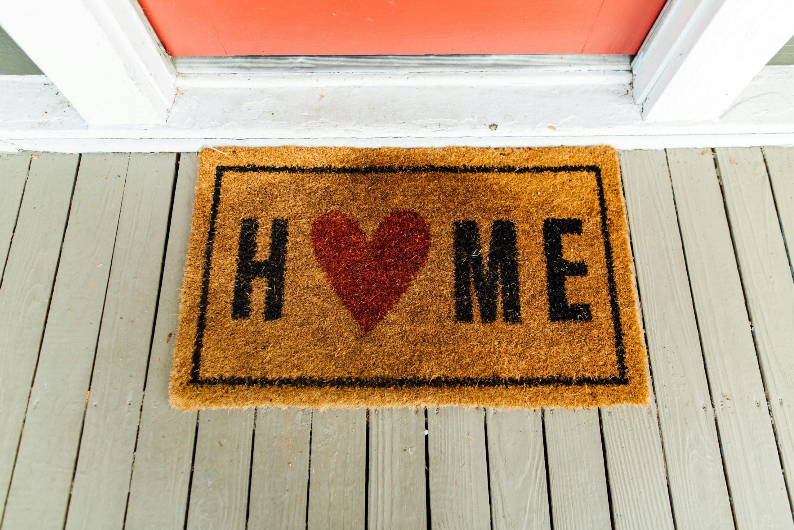 door mat that says "home" with a heart instead of an "O"